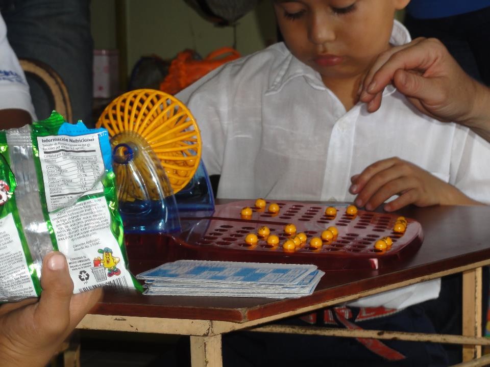 The importance of games in learning social-emotional skills and language. The students are playing Bingo.